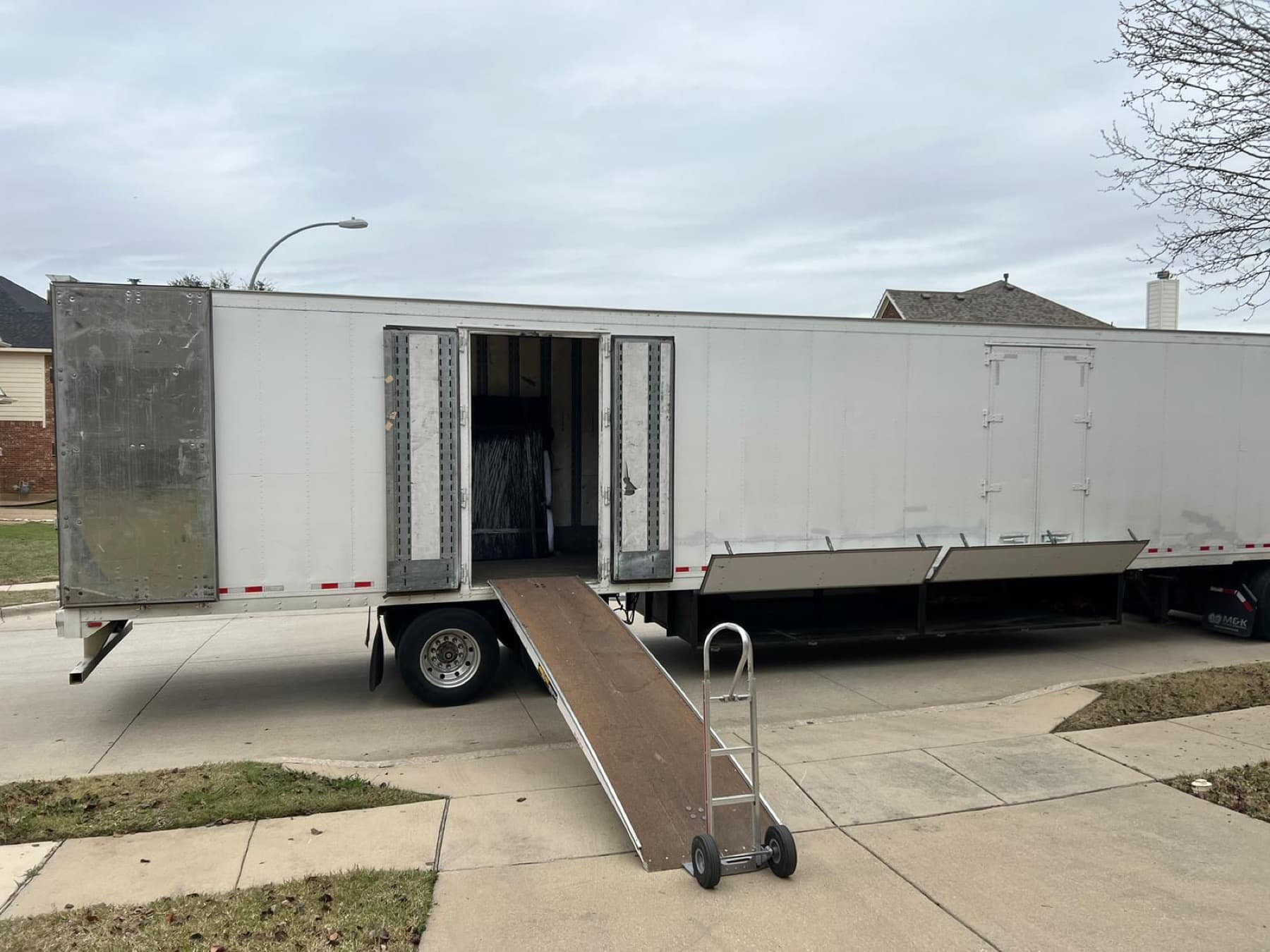 Moving truck with loading ramp ready at a home